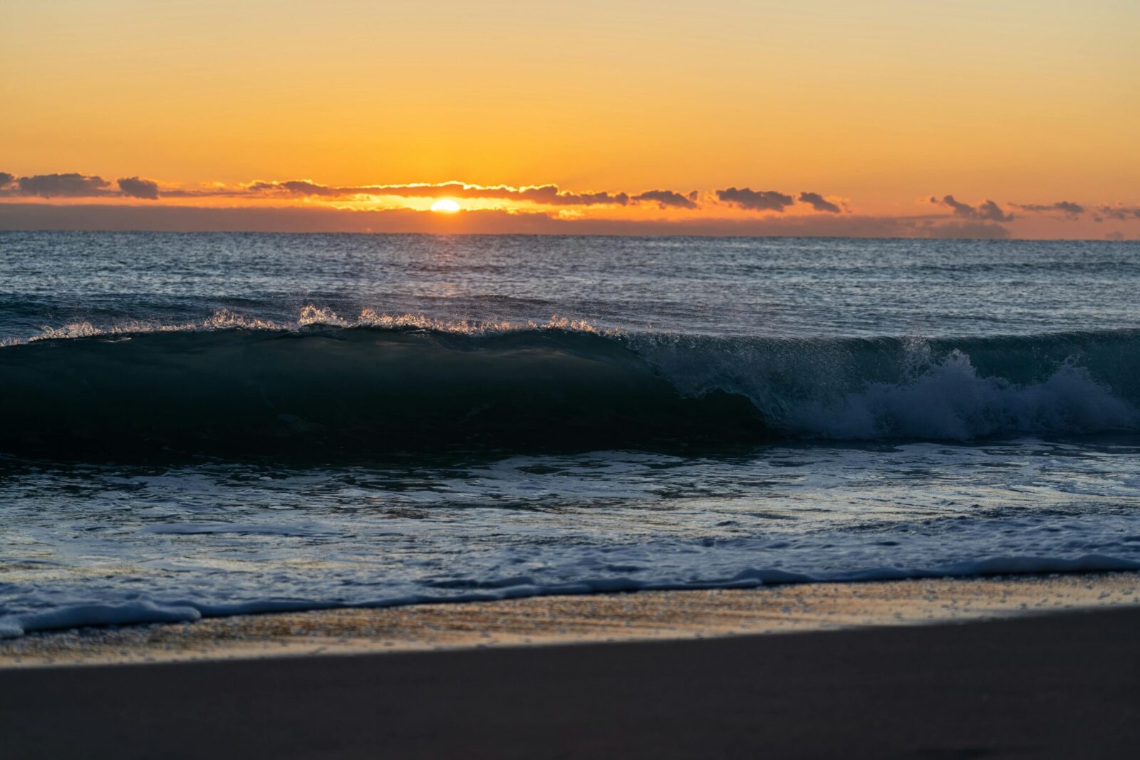 Capture of a stunning sunset over Valencia beach with waves crashing gently on the shore.