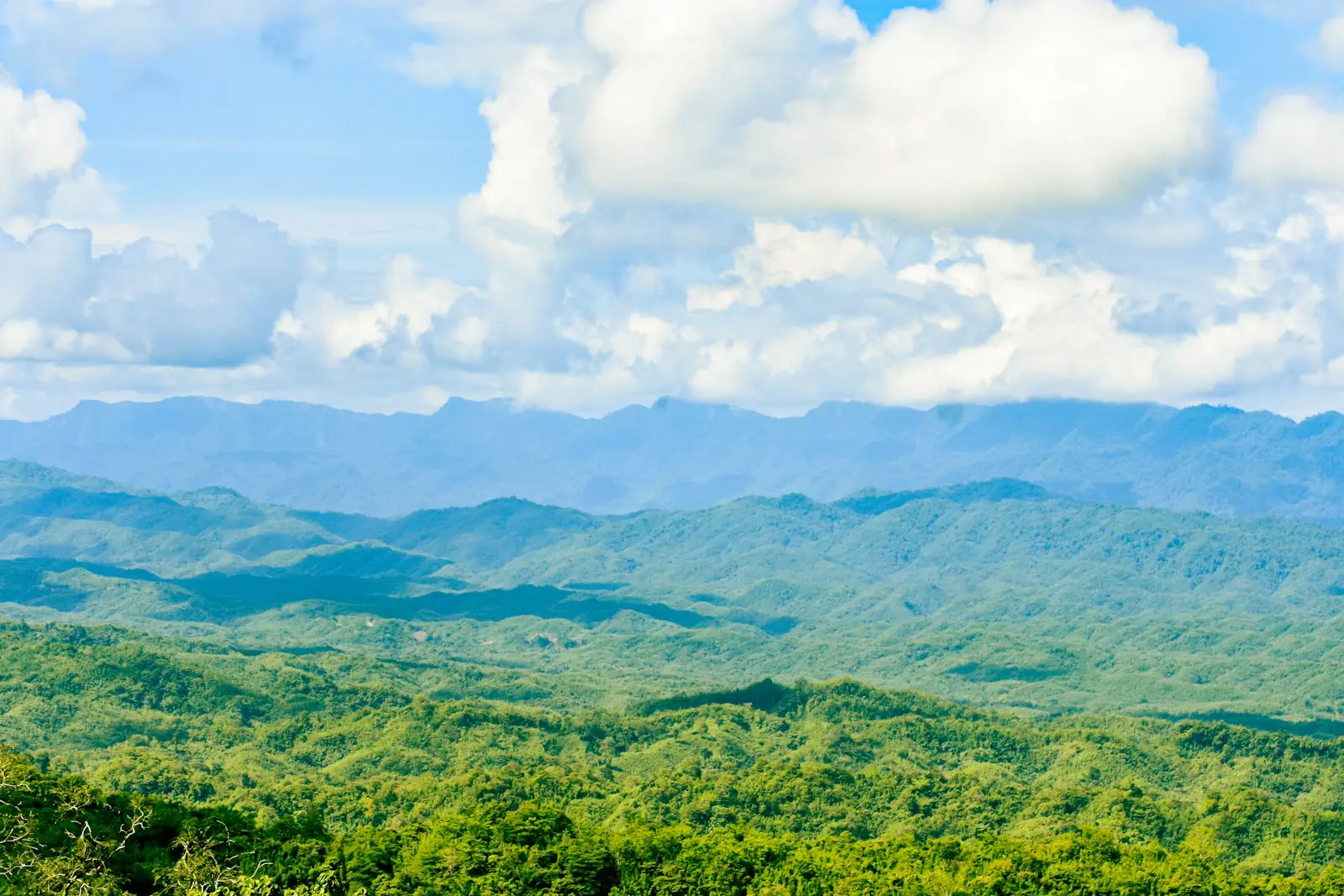 A scenic view of a mountain range with clouds in the sky