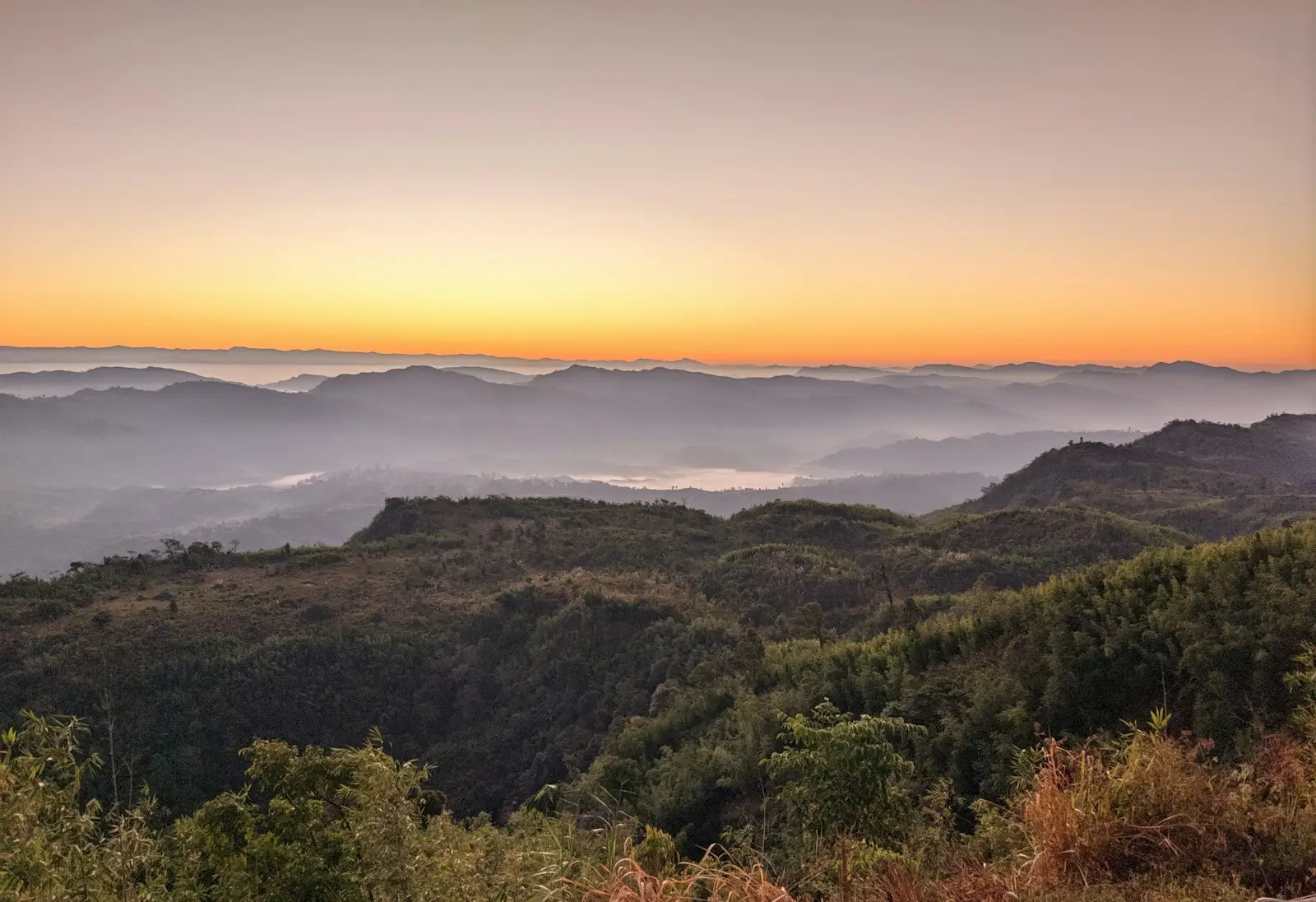 the sun is setting over a mountain range