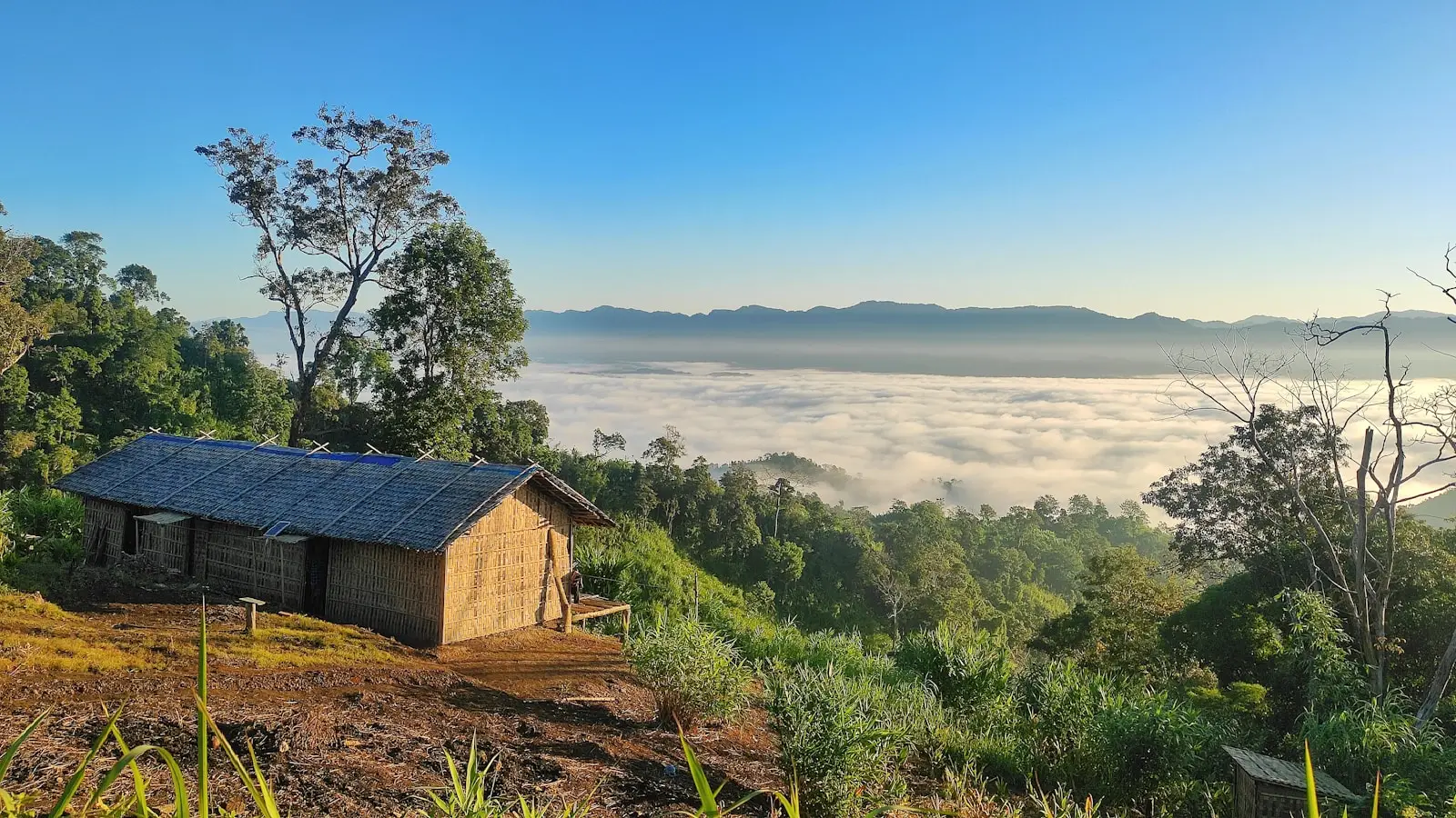 a small cabin on a hill above the clouds